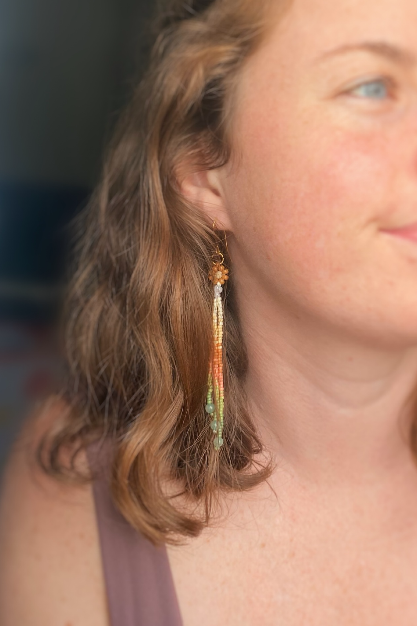 Close-up of a person wearing colorful beaded earrings